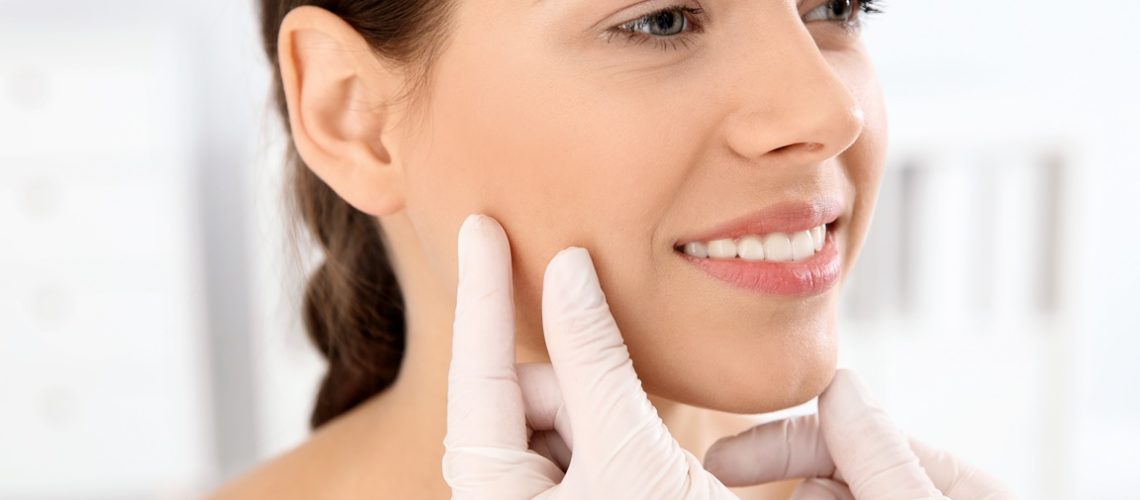 Dermatologist examining patient's face in clinic. Skin cancer checkup